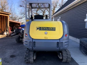 Civilized Construction & Excavation’s branded mini excavator on-site in Eastern Idaho, ready for trenching and septic system prep work.